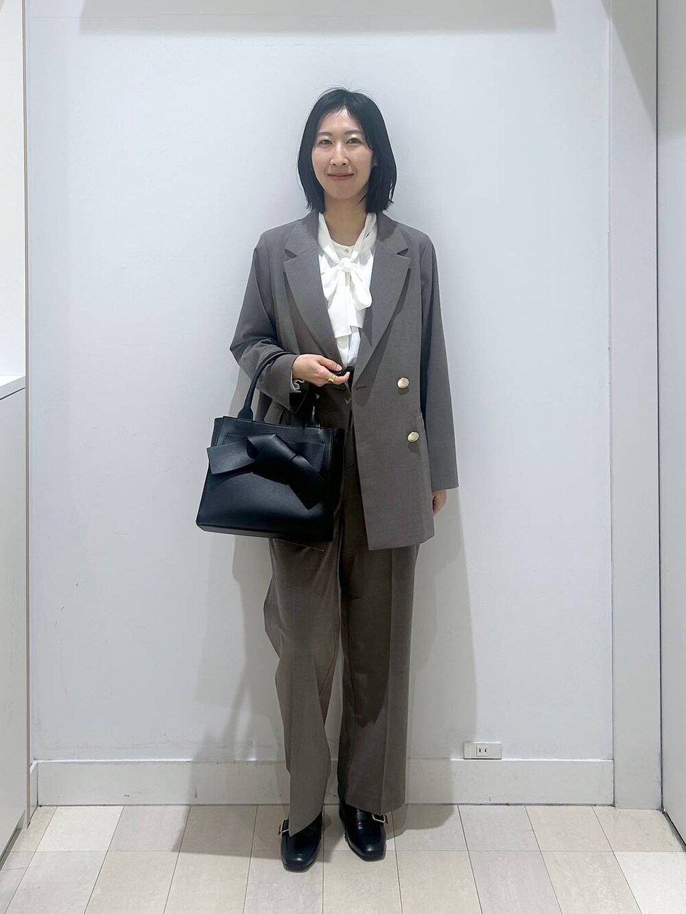 ブラック系のローファー、ブラウン系のスラックス、ホワイト系のシャツ/ブラウスを着用したレディースの冬コーディネートの5枚目の写真