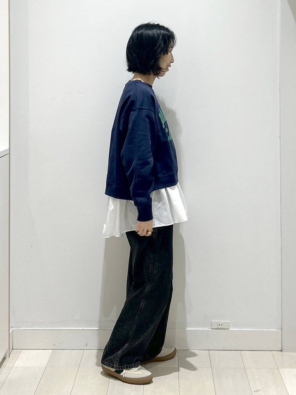 ベージュ系のスニーカー、ブラック系のデニムパンツ、ホワイト系のTシャツ/カットソーを着用したレディースの秋コーディネートの2枚目の写真