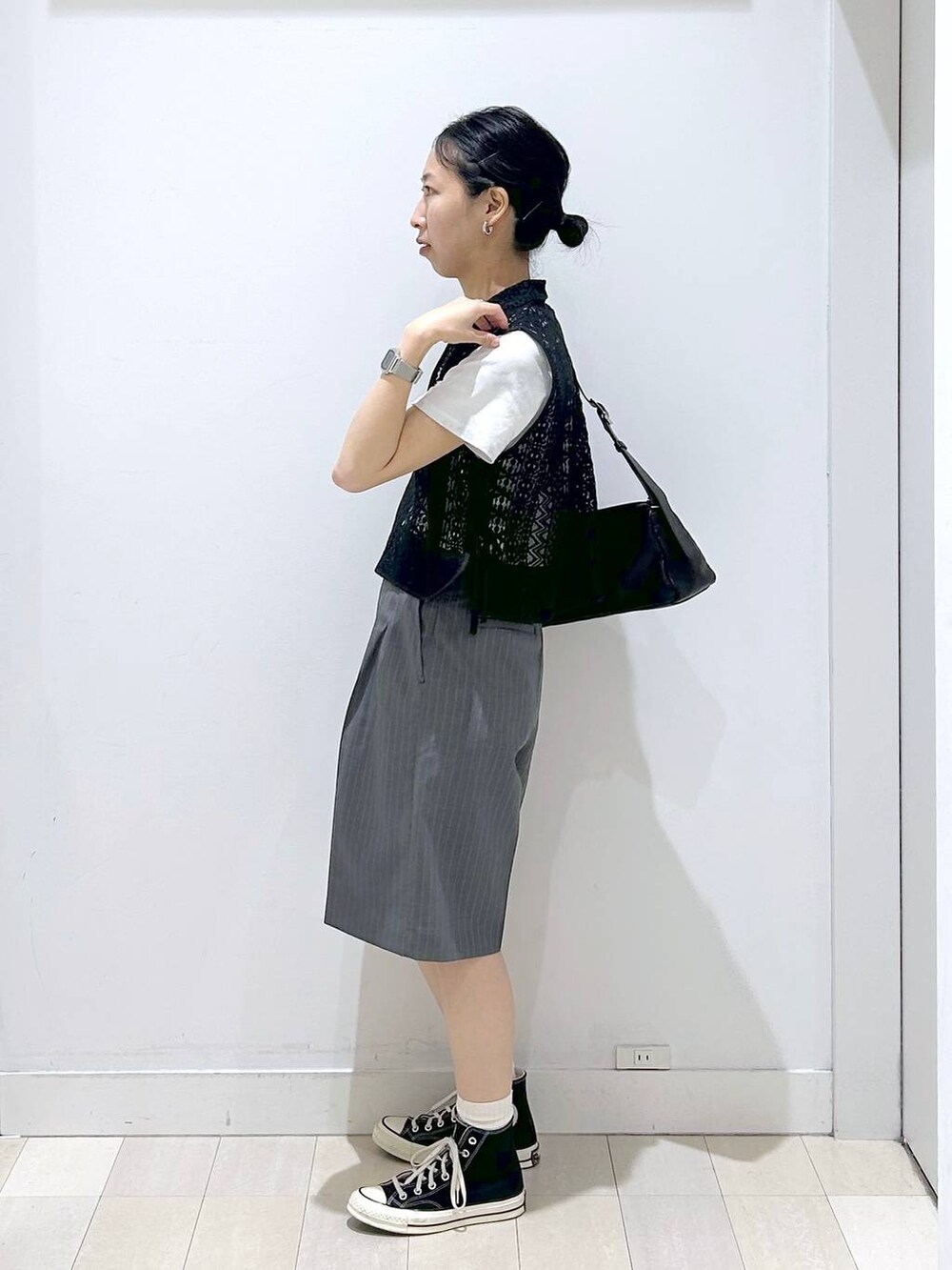 ブラック系のショルダーバッグ、ホワイト系のTシャツ/カットソー、ブラック系のベストを着用したレディースの夏コーディネートの2枚目の写真