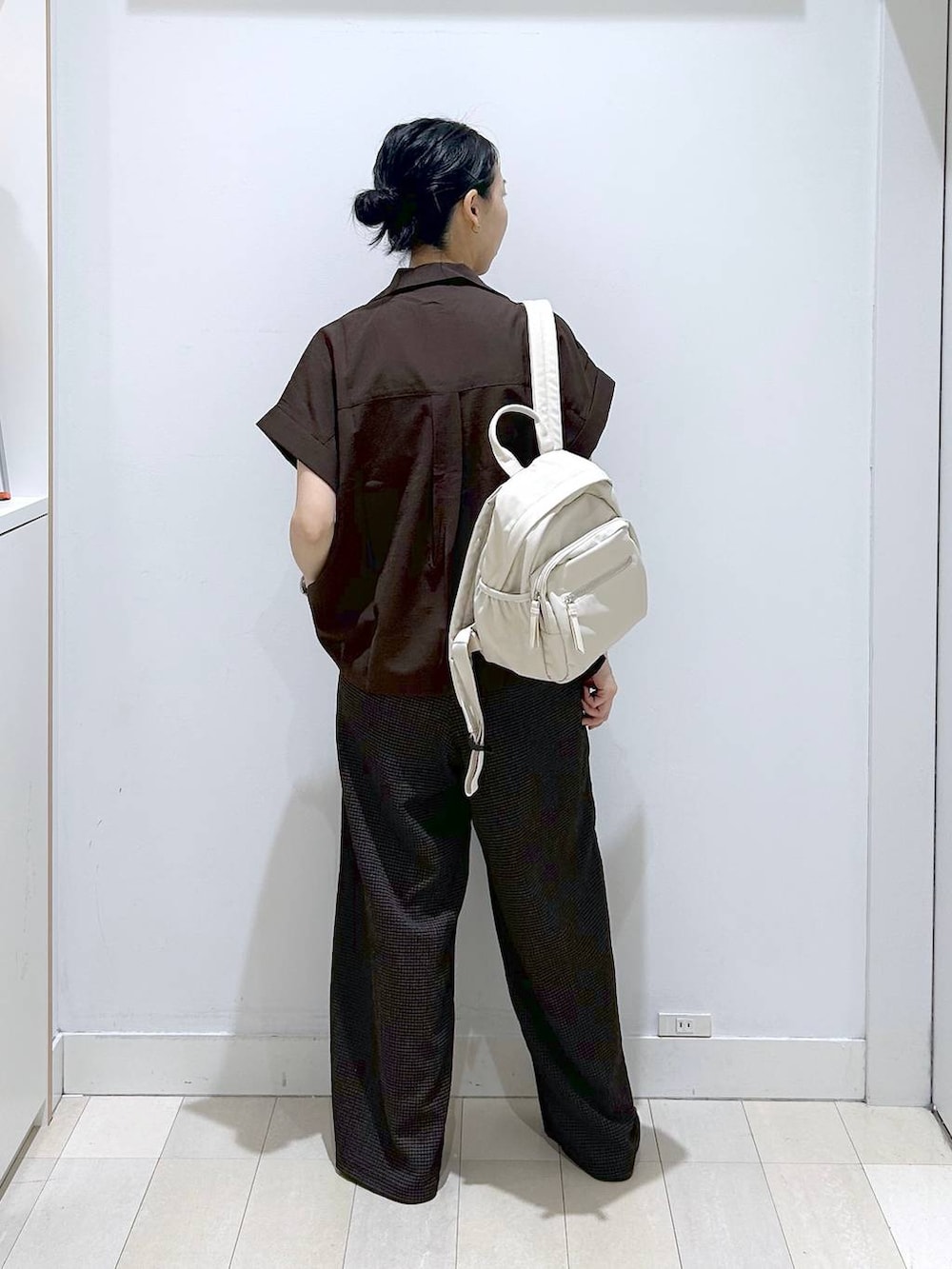 ブラウン系のシャツ/ブラウス、ブラック系のサンダル、ホワイト系のバックパック/リュックを着用したレディースの夏コーディネートの3枚目の写真