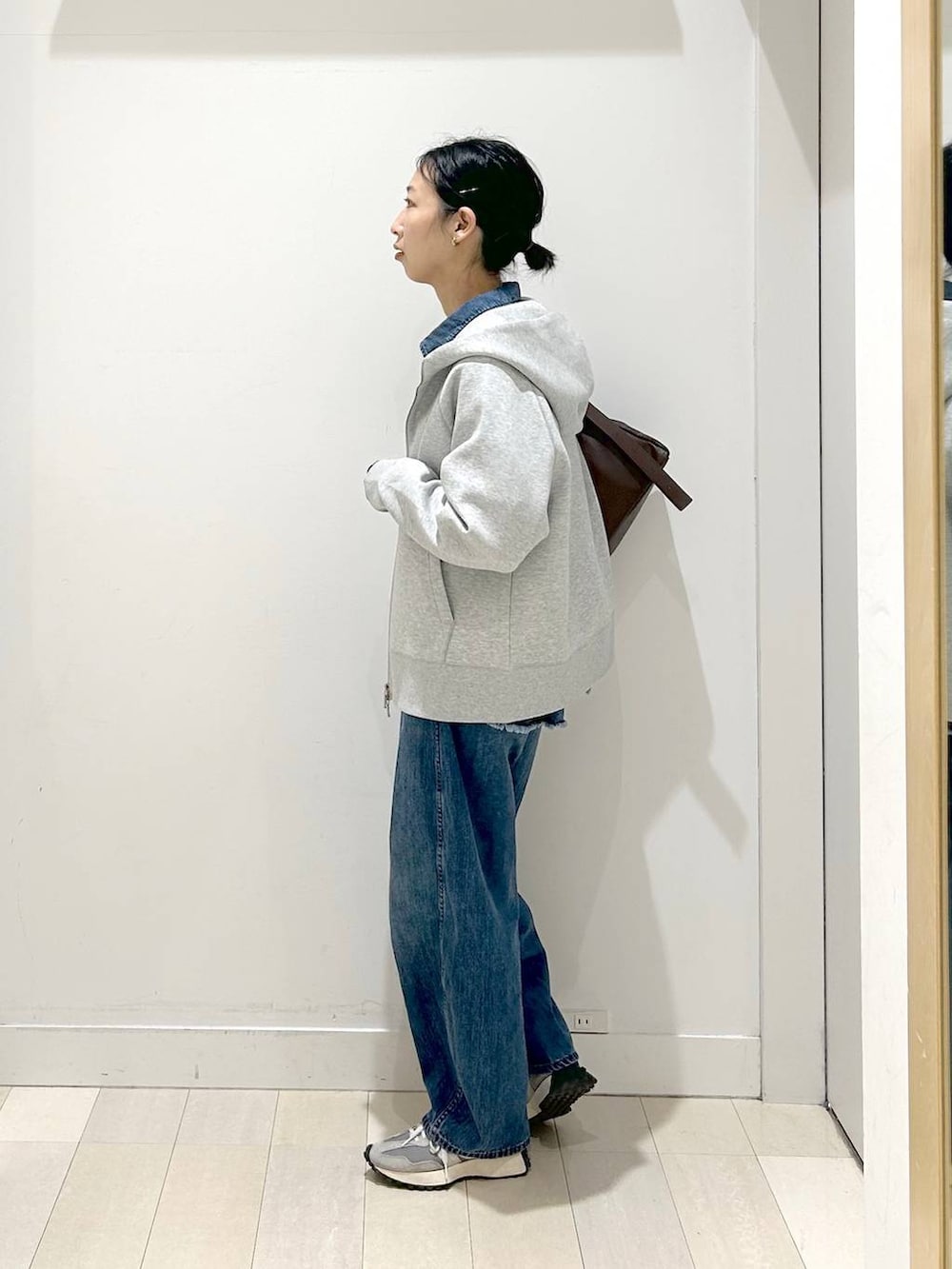 ブラック系のTシャツ/カットソー、グレー系のパーカー、ブルー系のデニムパンツを着用したレディースの冬コーディネートの4枚目の写真