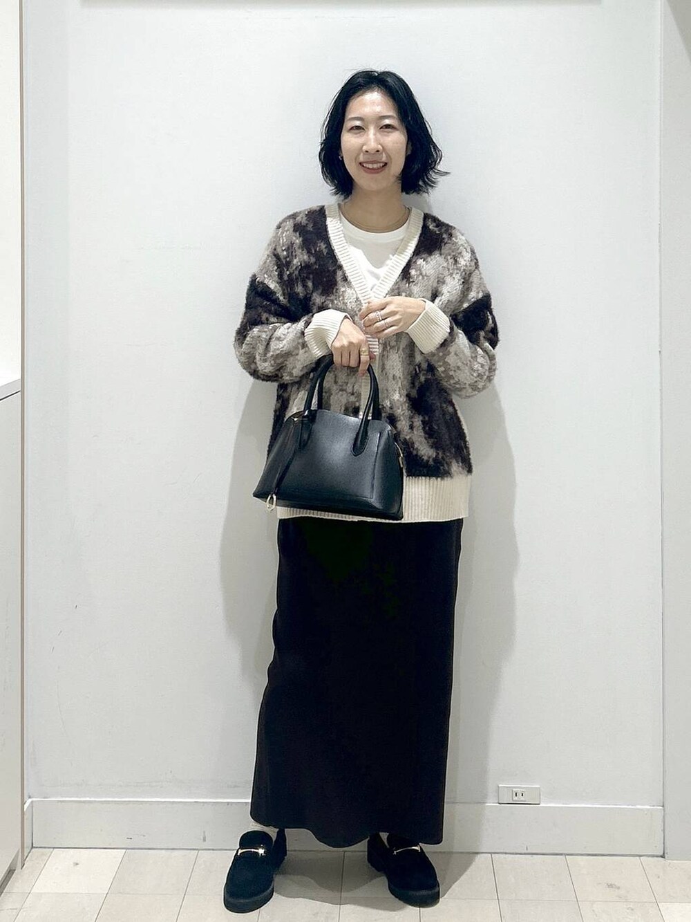 ブラック系のショルダーバッグ、ブラック系のローファー、ホワイト系のTシャツ/カットソーを着用したレディースの秋コーディネートの5枚目の写真