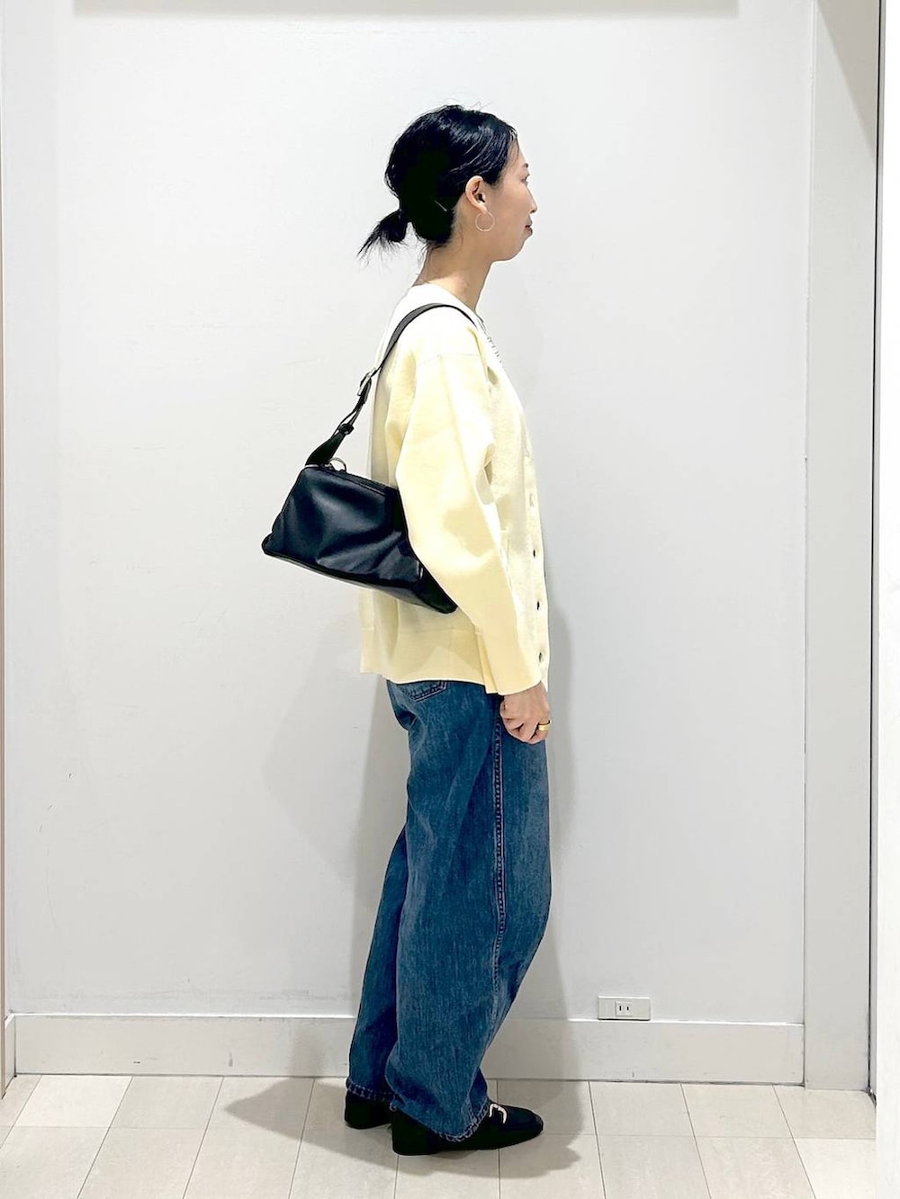 ブラック系のローファー、ブルー系のデニムパンツ、イエロー系のカーディガン/ボレロを着用したレディースの春コーディネートの4枚目の写真