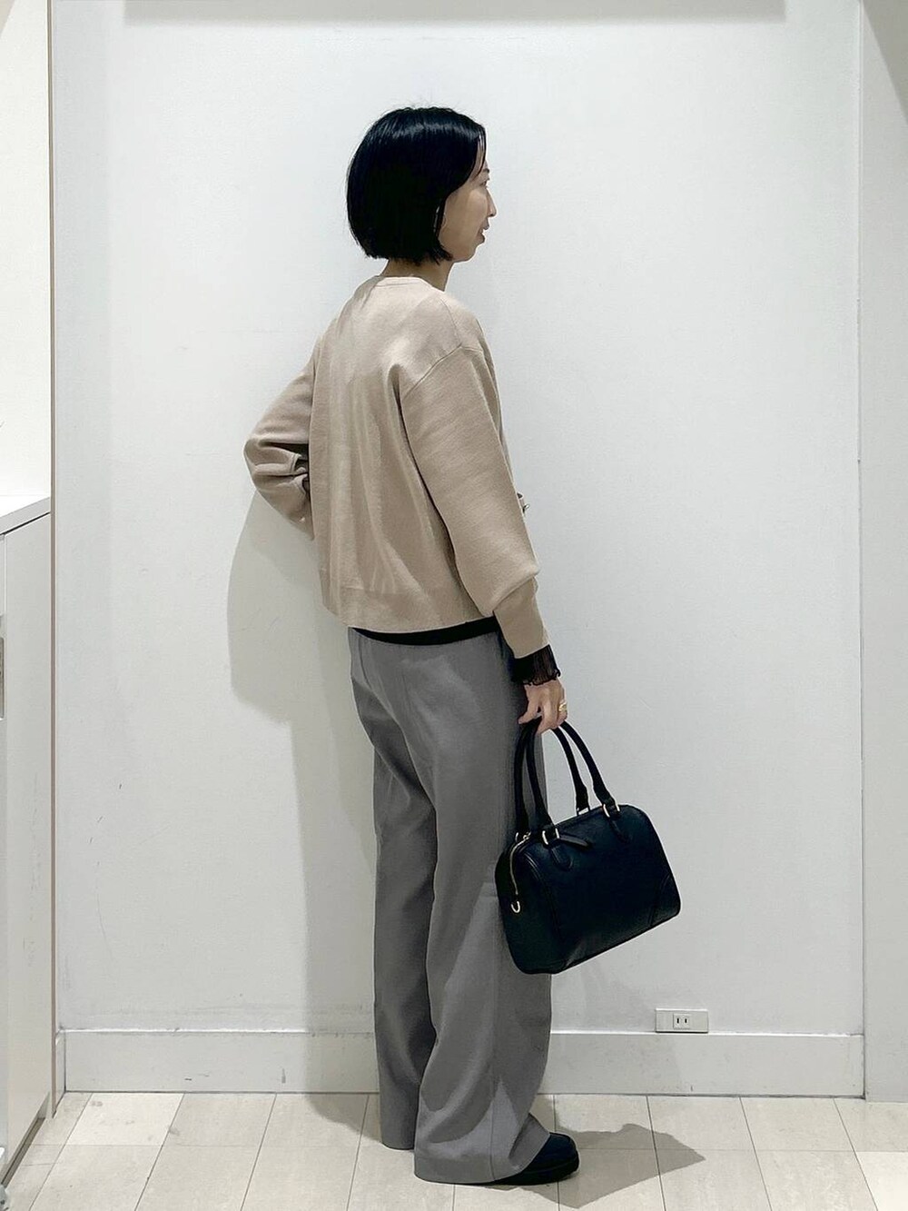 ブラック系のローファー、ブラック系のTシャツ/カットソー、グレー系のその他パンツを着用したレディースの秋コーディネートの2枚目の写真