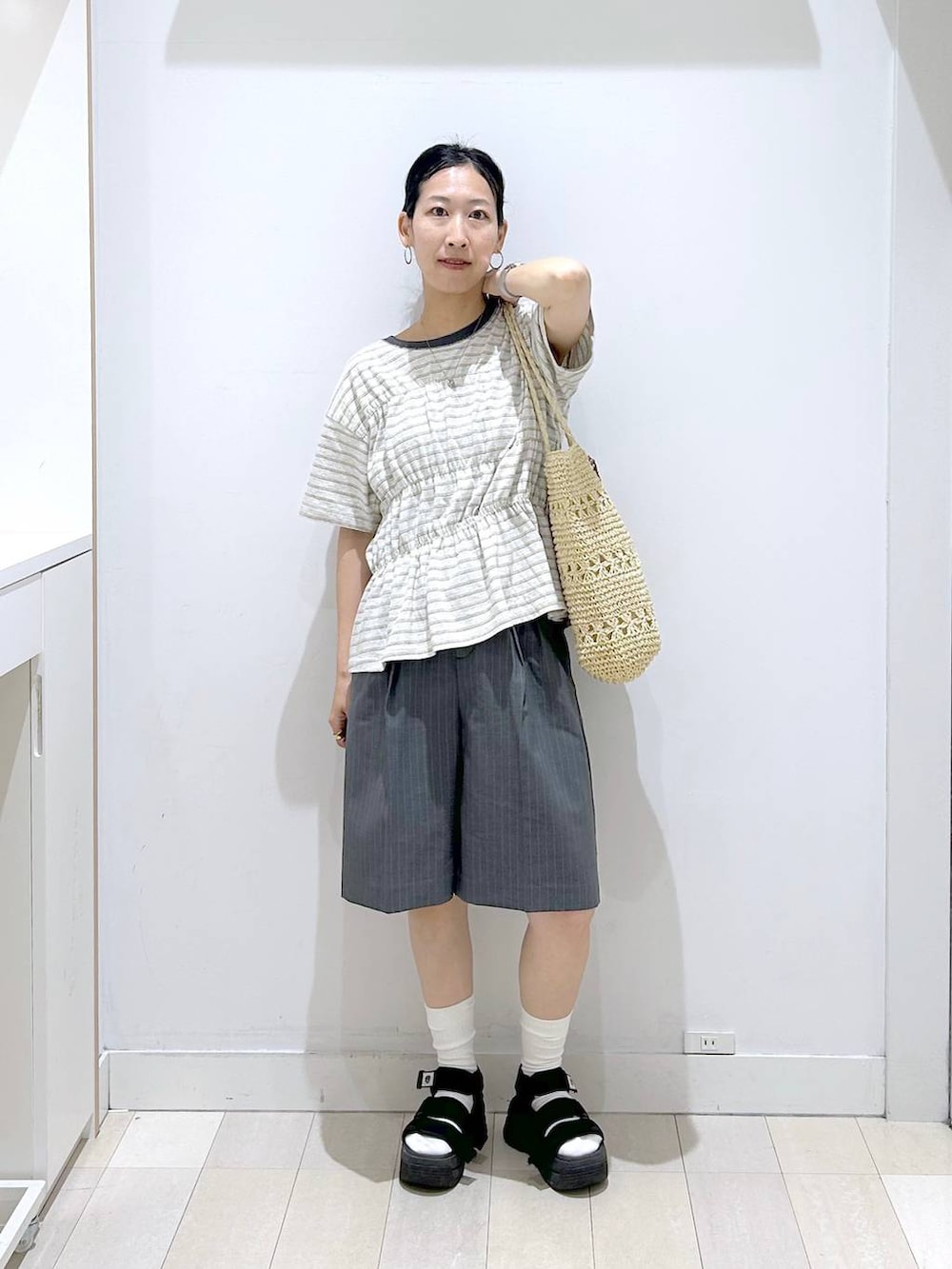 ベージュ系のトートバッグ、グレー系のその他パンツ、ホワイト系のTシャツ/カットソーを着用したレディースの夏コーディネートの5枚目の写真
