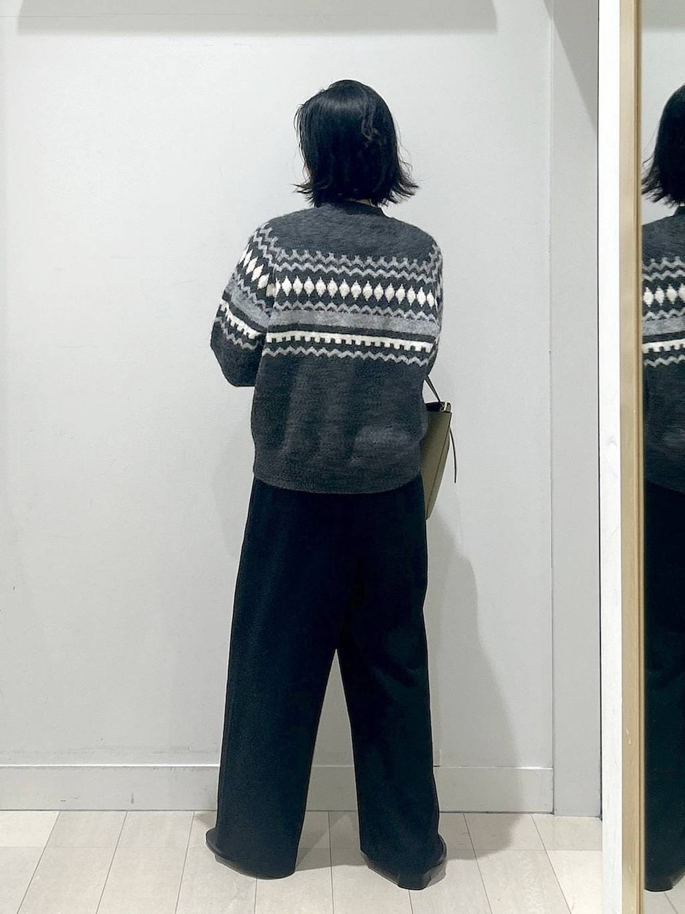 グリーン系のショルダーバッグ、グレー系のニット/セーター、ブラック系のその他パンツを着用したレディースの冬コーディネートの3枚目の写真