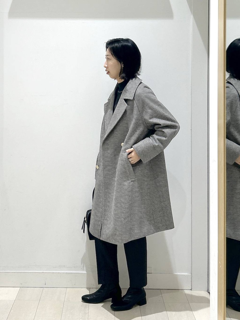 ブラウン系のチェスターコート、グレー系のその他パンツ、グレー系のニット/セーターを着用したレディースの冬コーディネートの4枚目の写真