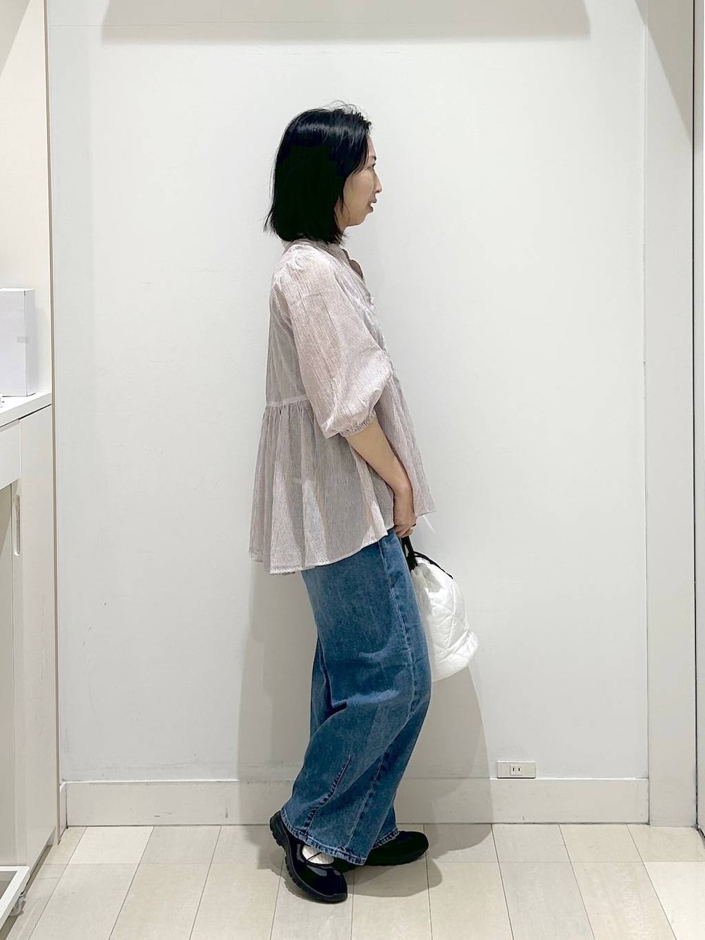 ホワイト系のハンドバッグ、ブルー系のデニムパンツ、レッド系のシャツ/ブラウスを着用したレディースの春コーディネートの4枚目の写真
