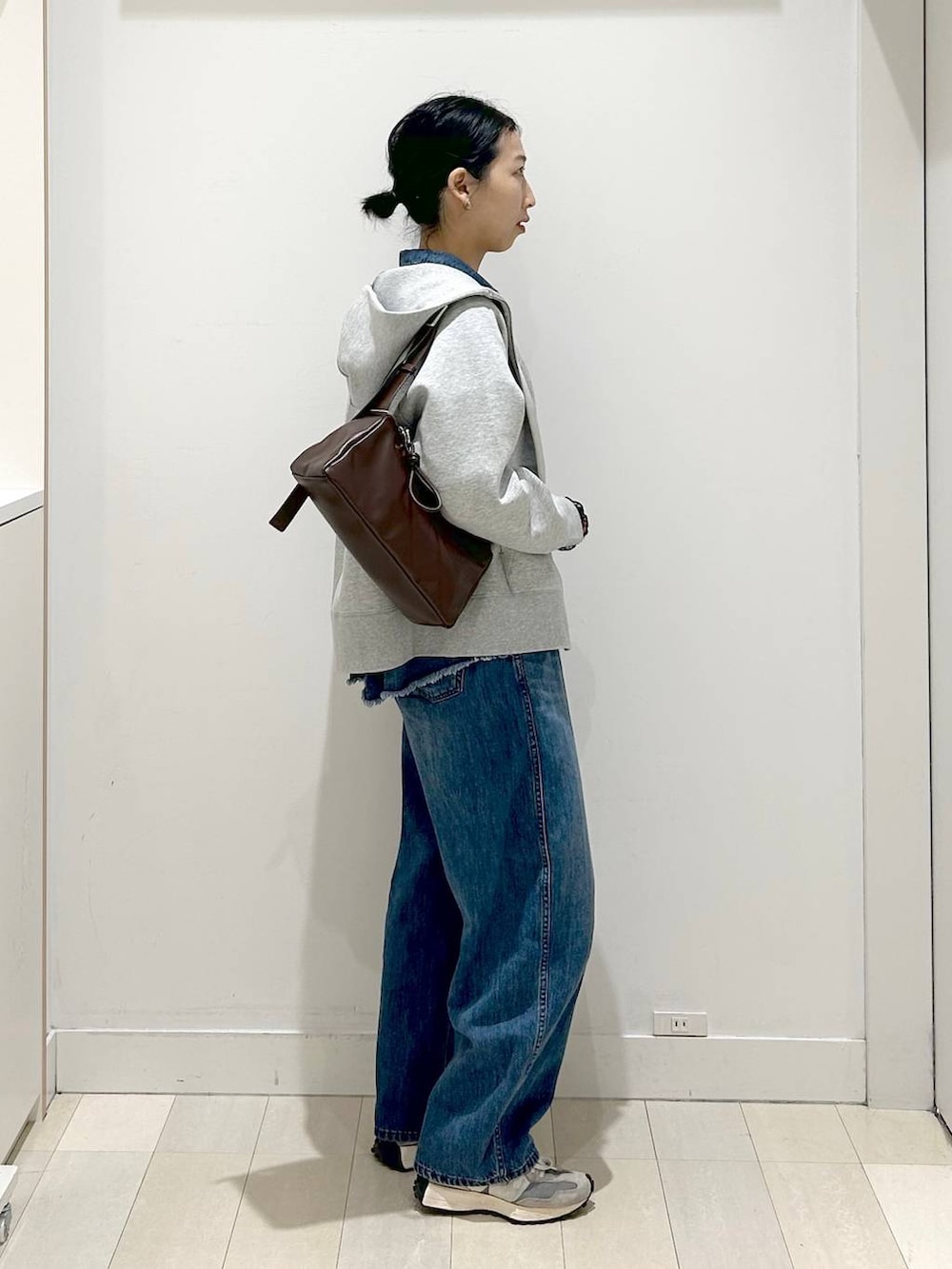 ブラック系のTシャツ/カットソー、グレー系のパーカー、ブルー系のデニムパンツを着用したレディースの冬コーディネートの2枚目の写真