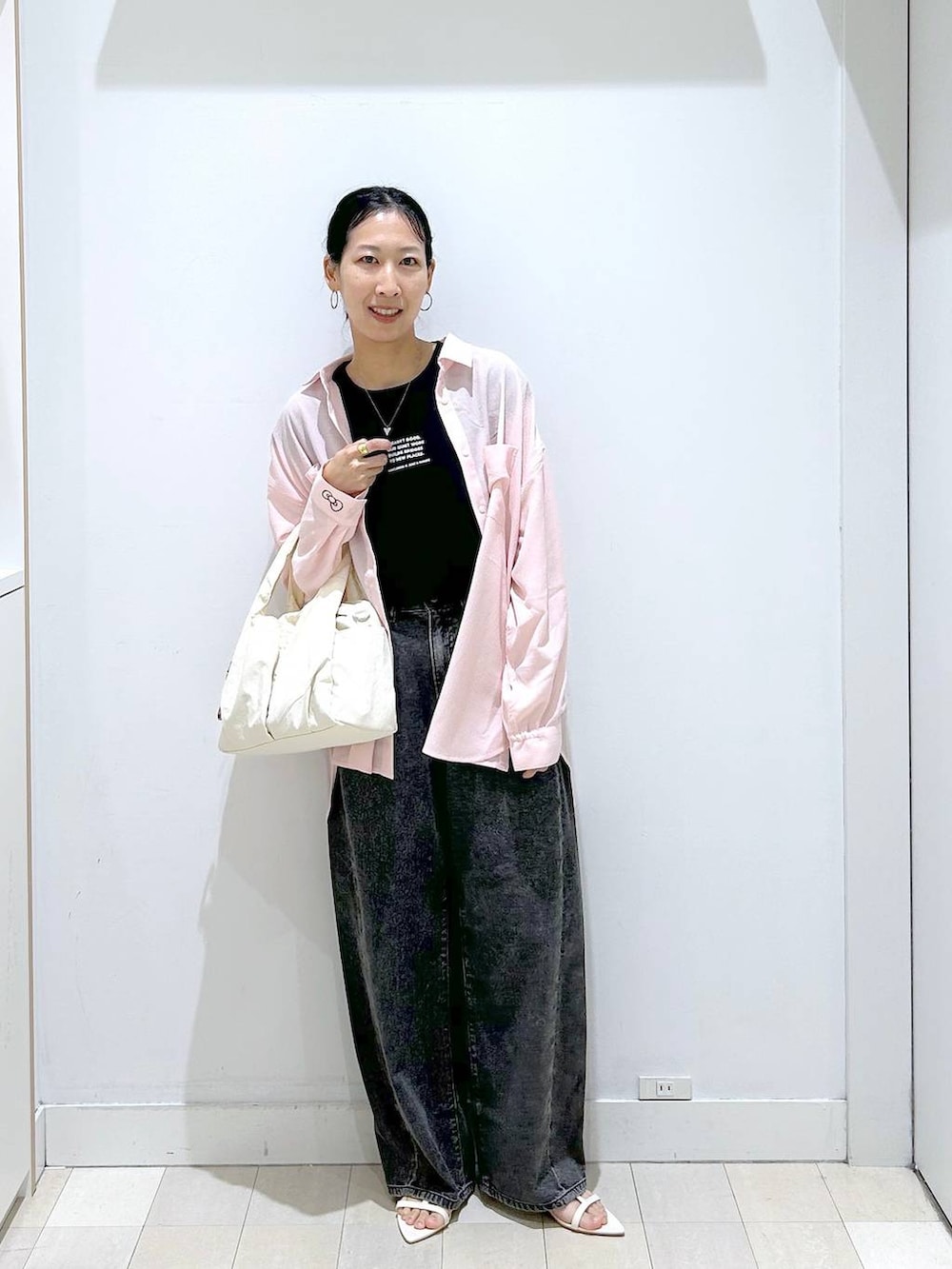 ホワイト系のトートバッグ、ブラック系のデニムパンツ、ブラック系のTシャツ/カットソーを着用したレディースの夏コーディネートの5枚目の写真