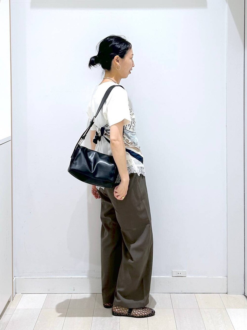 ブラウン系のその他パンツ、ブラック系のショルダーバッグ、ベージュ系のTシャツ/カットソーを着用したレディースの夏コーディネートの4枚目の写真