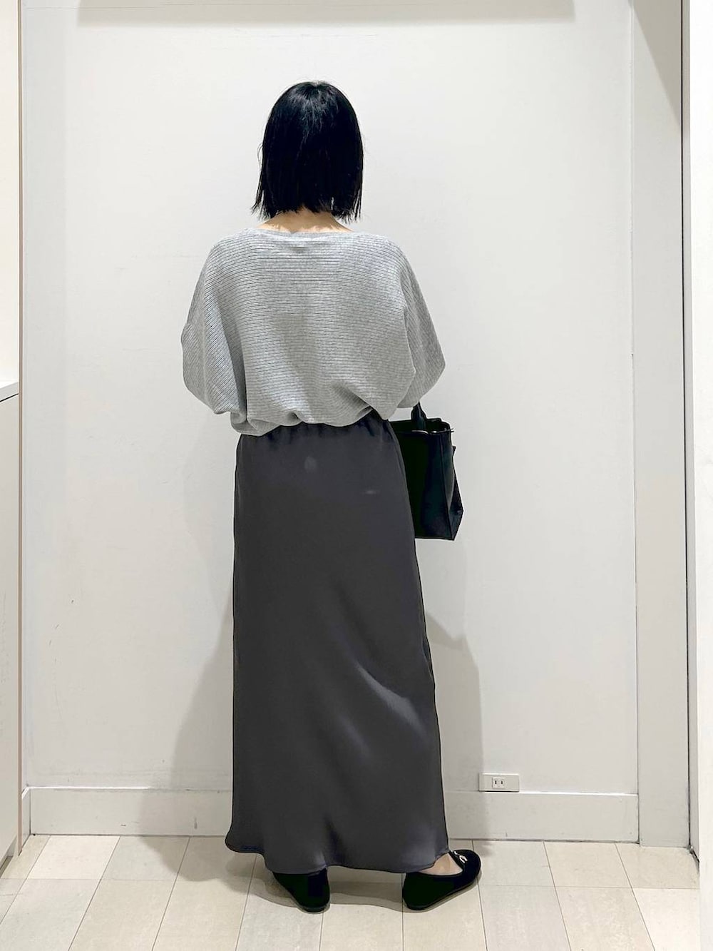 ブラック系のローファー、グレー系のニット/セーター、ブラック系のハンドバッグを着用したレディースの冬コーディネートの3枚目の写真