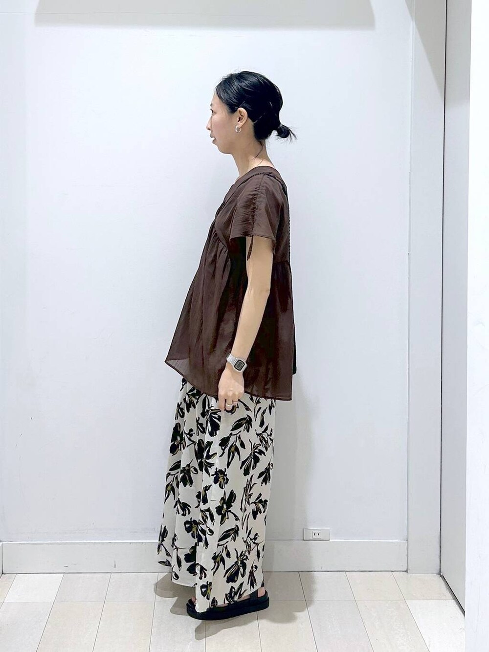 ホワイト系のその他パンツ、ブラウン系のシャツ/ブラウス、ブラック系のクラッチバッグを着用したレディースの春コーディネートの2枚目の写真