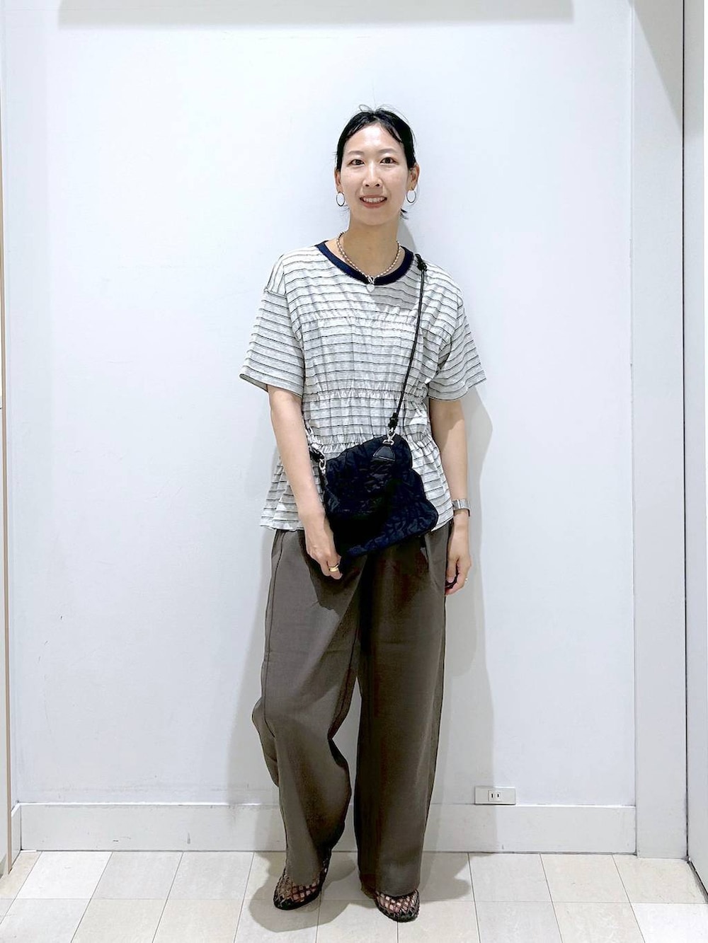 ブラウン系のその他パンツ、ブラック系のサンダル、グレー系のTシャツ/カットソーを着用したレディースの夏コーディネートの5枚目の写真