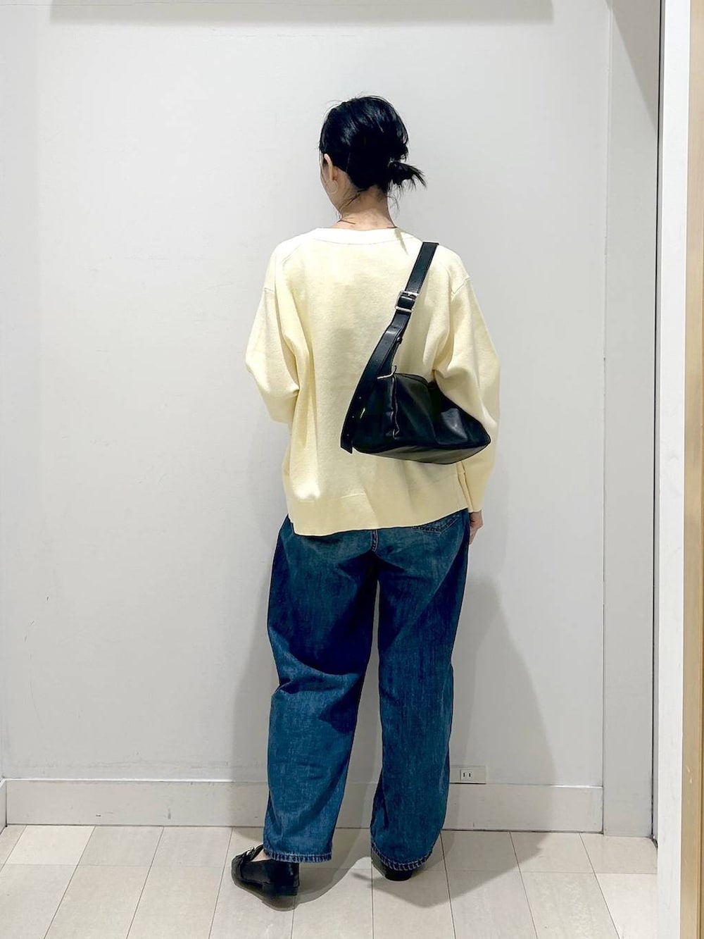 ブラック系のローファー、ブルー系のデニムパンツ、イエロー系のカーディガン/ボレロを着用したレディースの春コーディネートの3枚目の写真