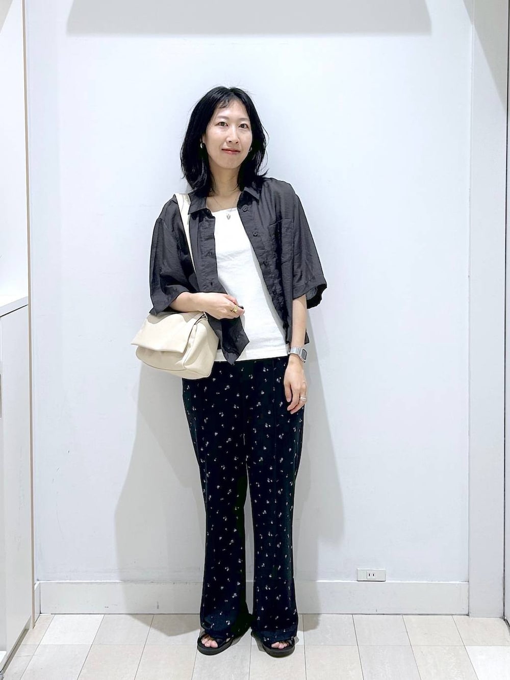 グレー系のシャツ/ブラウス、ホワイト系のタンクトップ、ブラック系のサンダルを着用したレディースの夏コーディネートの5枚目の写真
