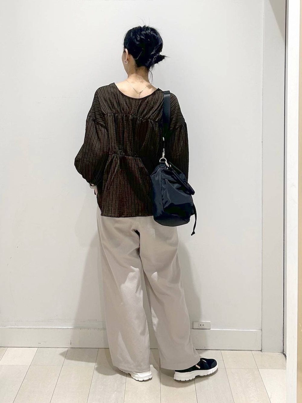 ブラック系のスニーカー、ブラック系のショルダーバッグ、ホワイト系のその他パンツを着用したレディースの春コーディネートの3枚目の写真