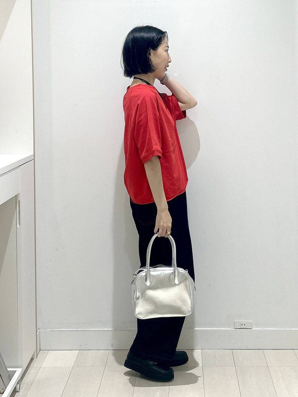 ブラック系のローファー、グレー系のボストンバッグ、ブルー系のデニムパンツを着用したレディースの秋コーディネートの2枚目の写真