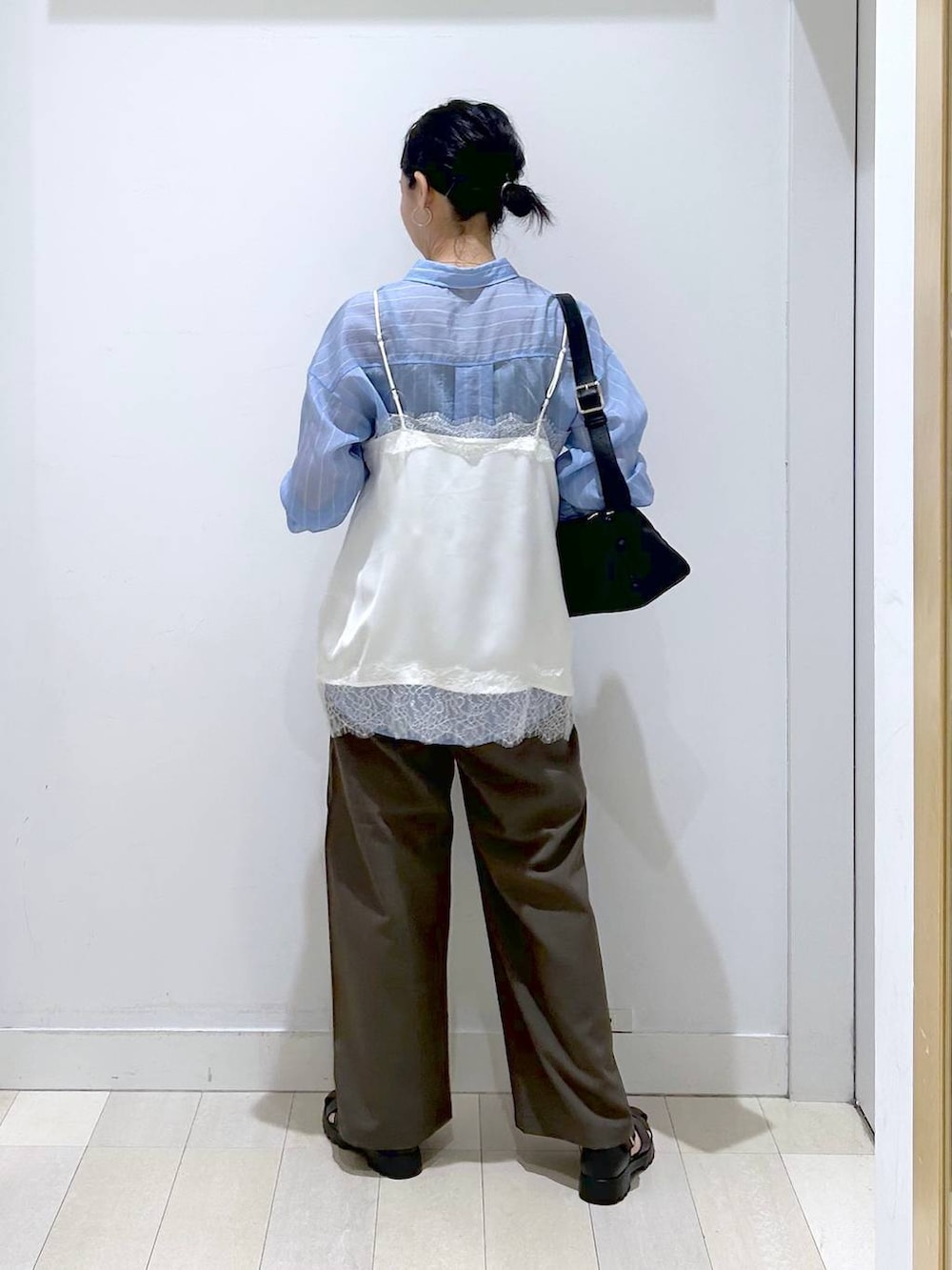 ブラウン系のその他パンツ、ブラック系のショルダーバッグ、ブルー系のシャツ/ブラウスを着用したレディースの春コーディネートの3枚目の写真