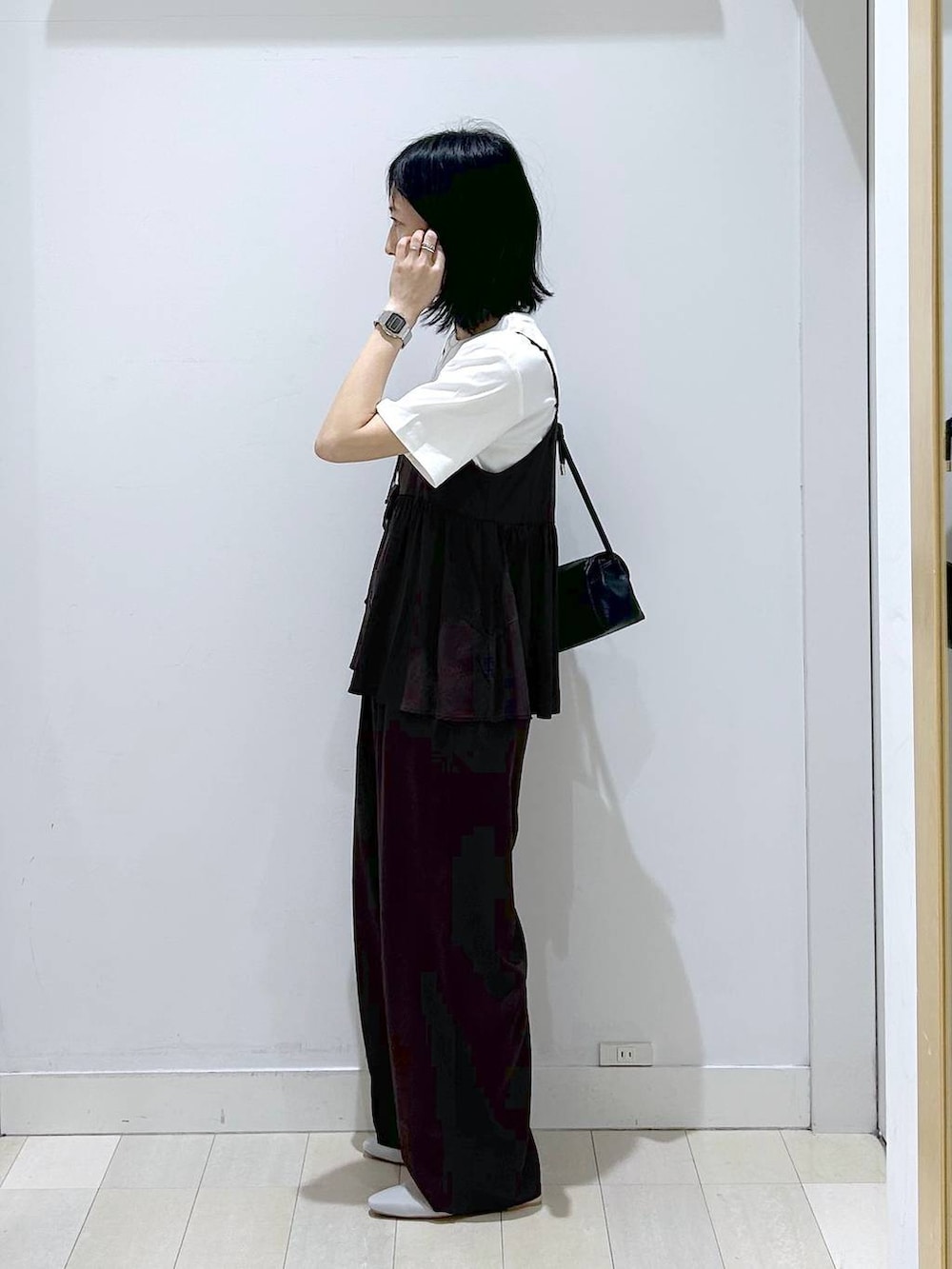 ブラック系のショルダーバッグ、ブラウン系のその他パンツ、ブラック系のTシャツ/カットソーを着用したレディースの春コーディネートの2枚目の写真