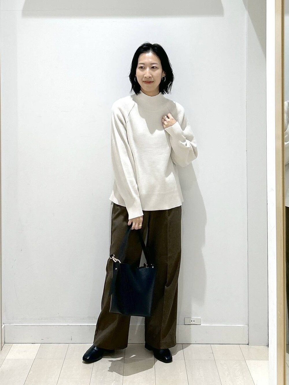 ブラック系のショルダーバッグ、ブラウン系のその他パンツ、ブラック系のブーツを着用したレディースの冬コーディネートの5枚目の写真