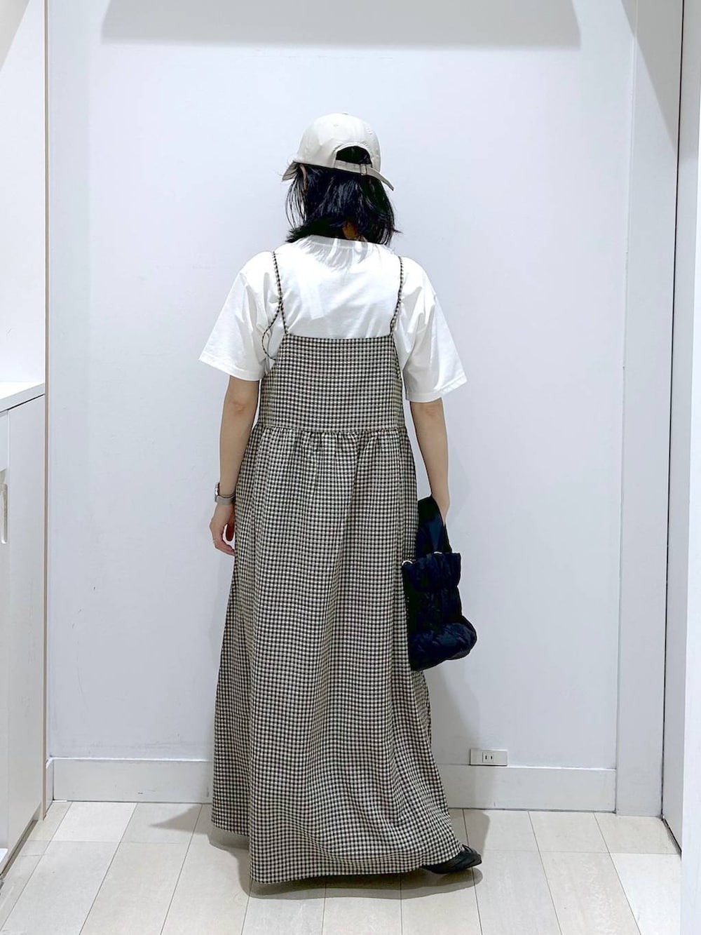 ブルー系のデニムパンツ、ブラック系のトートバッグ、ホワイト系のTシャツ/カットソーを着用したレディースの夏コーディネートの3枚目の写真