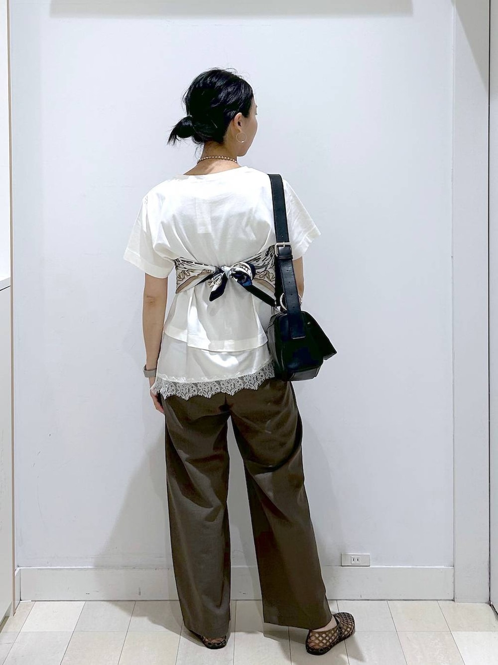 ブラウン系のその他パンツ、ブラック系のショルダーバッグ、ベージュ系のTシャツ/カットソーを着用したレディースの夏コーディネートの3枚目の写真