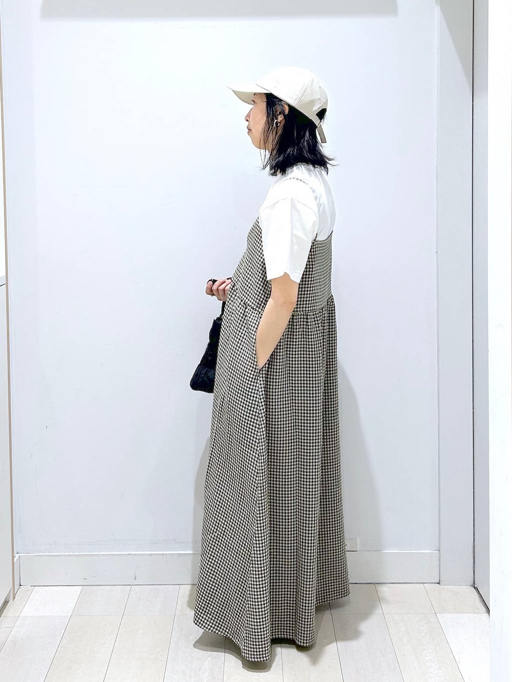 ブルー系のデニムパンツ、ブラック系のトートバッグ、ホワイト系のTシャツ/カットソーを着用したレディースの夏コーディネートの2枚目の写真