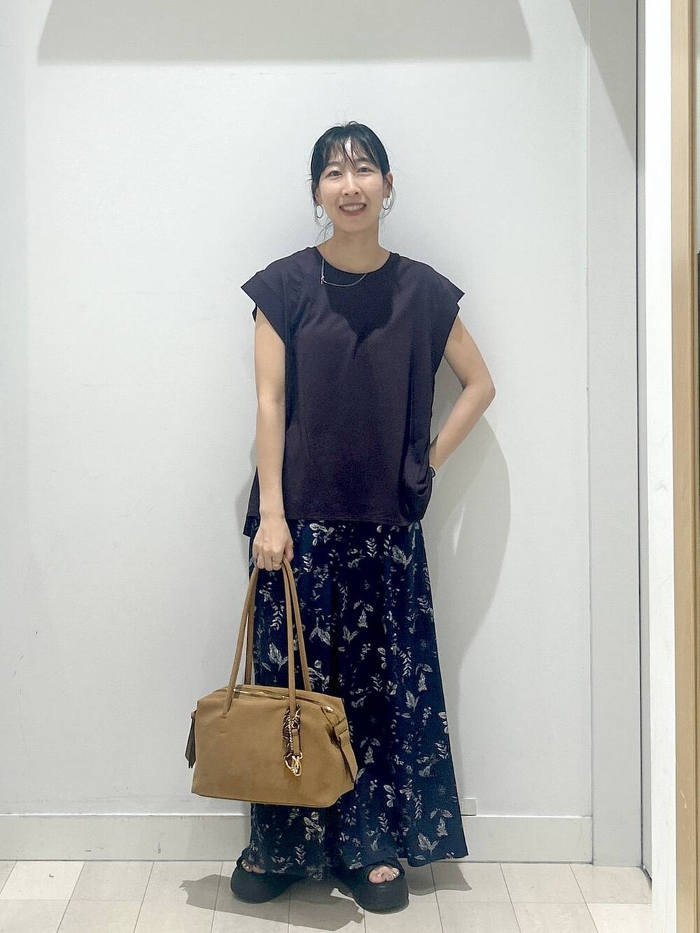 ブラック系のサンダル、ブラウン系のTシャツ/カットソー、ベージュ系のボストンバッグを着用したレディースの夏コーディネートの5枚目の写真