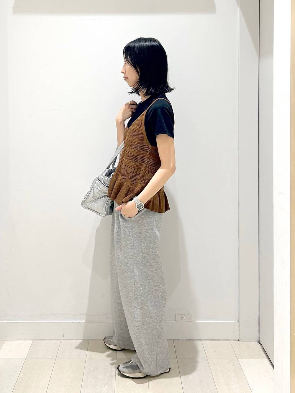 シルバー系のトートバッグ、ブラック系のTシャツ/カットソー、グレー系のその他パンツを着用したレディースの春コーディネートの2枚目の写真