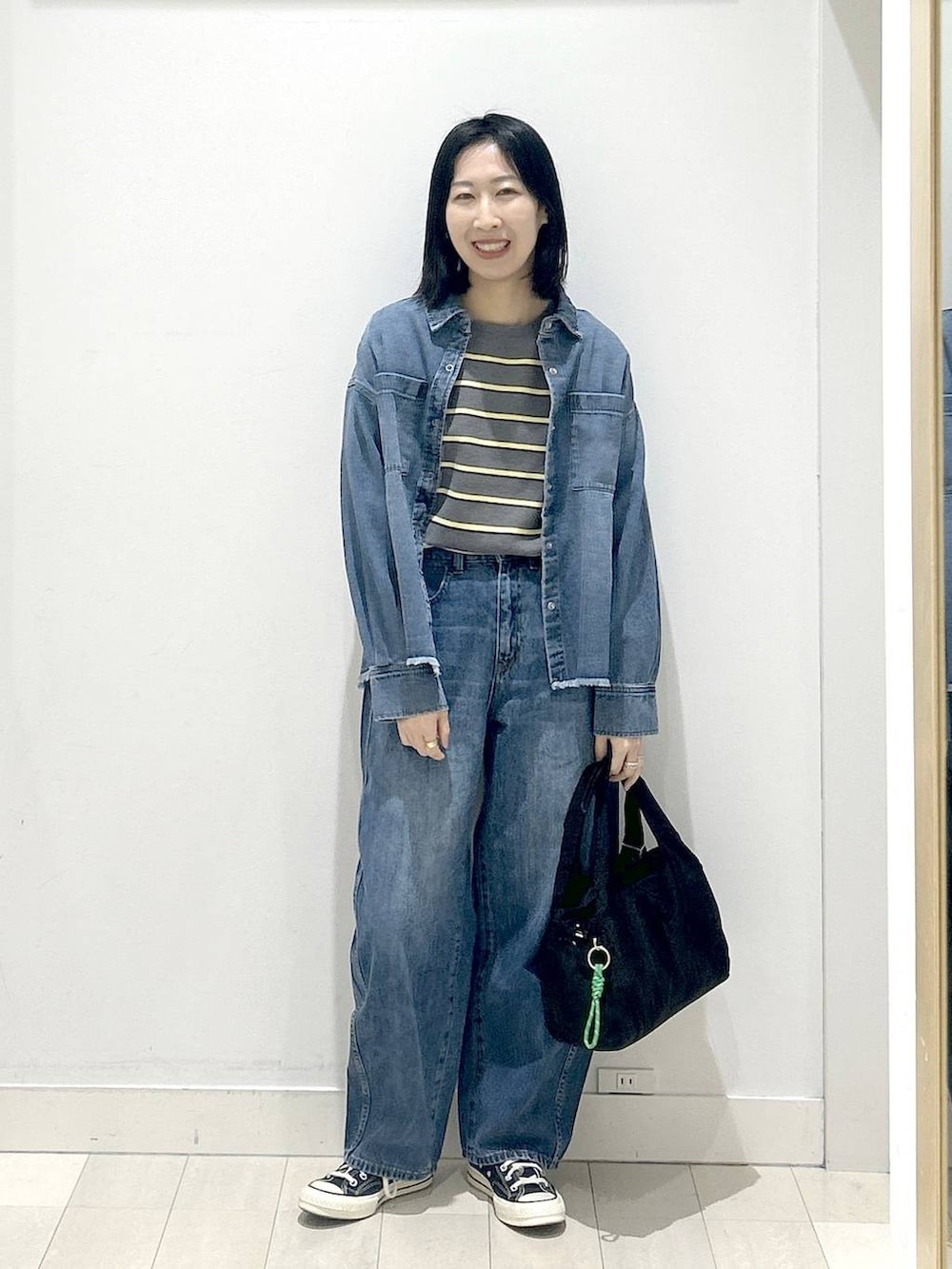 ブラック系のトートバッグ、ブルー系のシャツ/ブラウス、グレー系のニット/セーターを着用したレディースの冬コーディネートの5枚目の写真