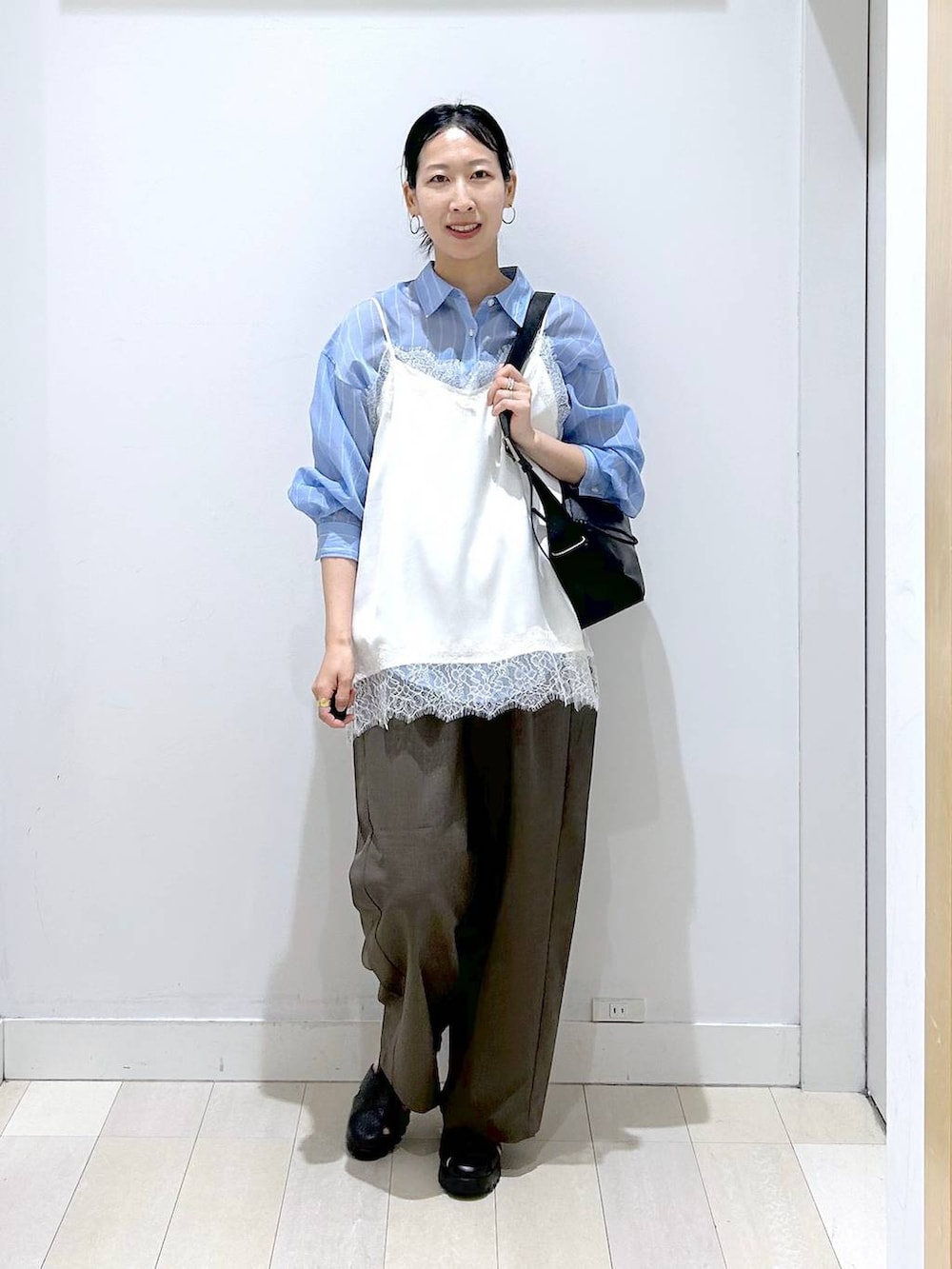 ブラウン系のその他パンツ、ブラック系のショルダーバッグ、ブルー系のシャツ/ブラウスを着用したレディースの春コーディネートの5枚目の写真