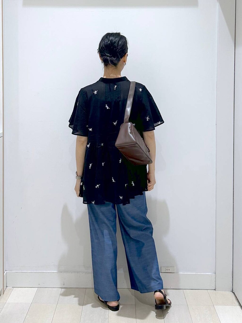 ブラウン系のショルダーバッグ、ブルー系のその他パンツ、ブラック系のサンダルを着用したレディースの夏コーディネートの3枚目の写真