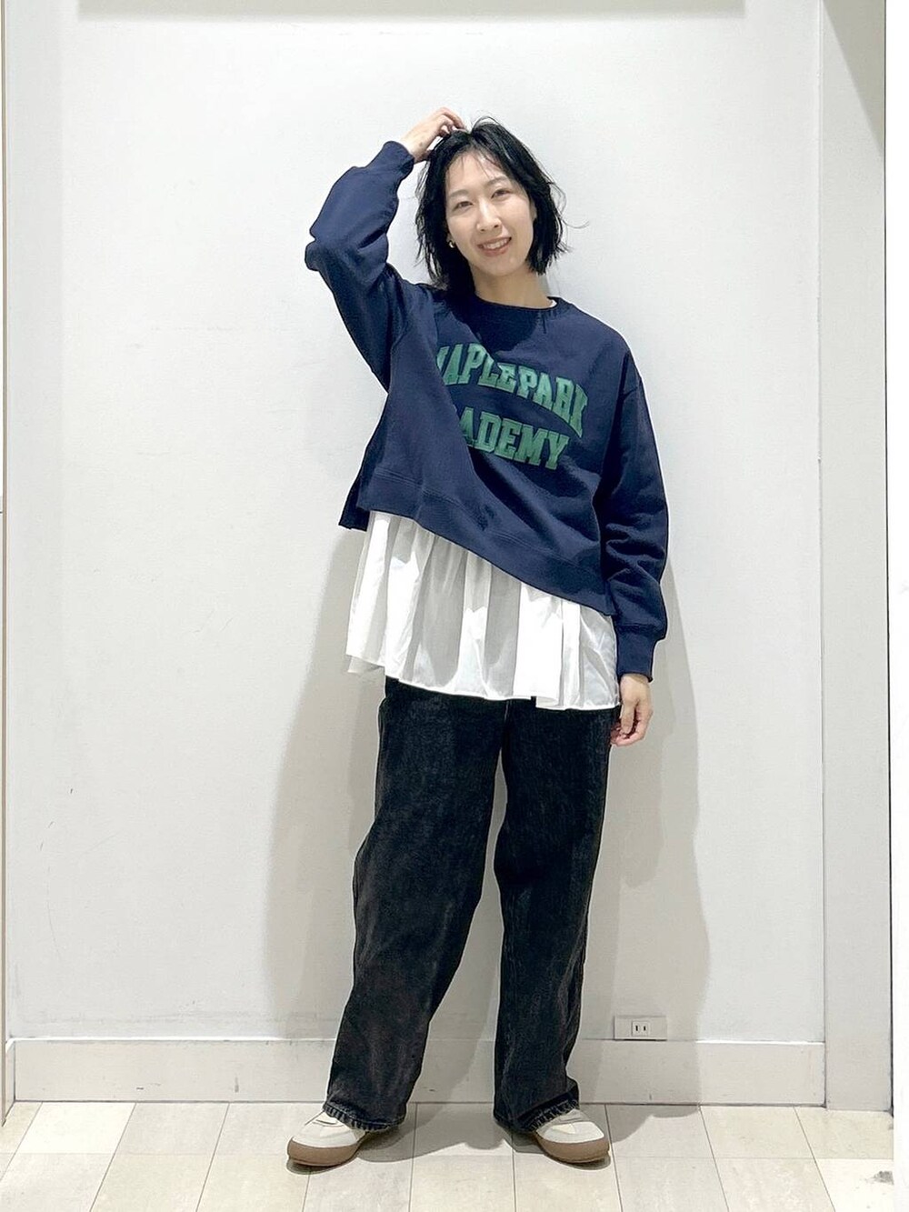 ベージュ系のスニーカー、ブラック系のデニムパンツ、ホワイト系のTシャツ/カットソーを着用したレディースの秋コーディネートの5枚目の写真