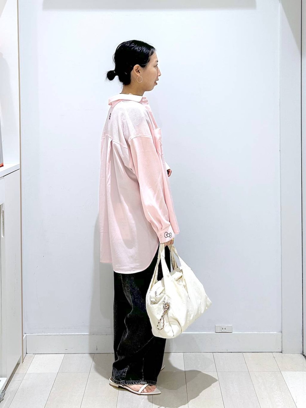 ホワイト系のトートバッグ、ブラック系のデニムパンツ、ブラック系のTシャツ/カットソーを着用したレディースの夏コーディネートの4枚目の写真