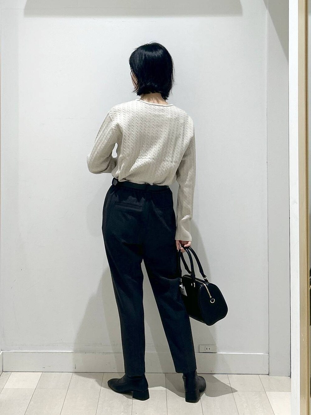 グレー系のその他パンツ、ブラック系のボストンバッグ、ブラック系のブーツを着用したレディースの冬コーディネートの3枚目の写真