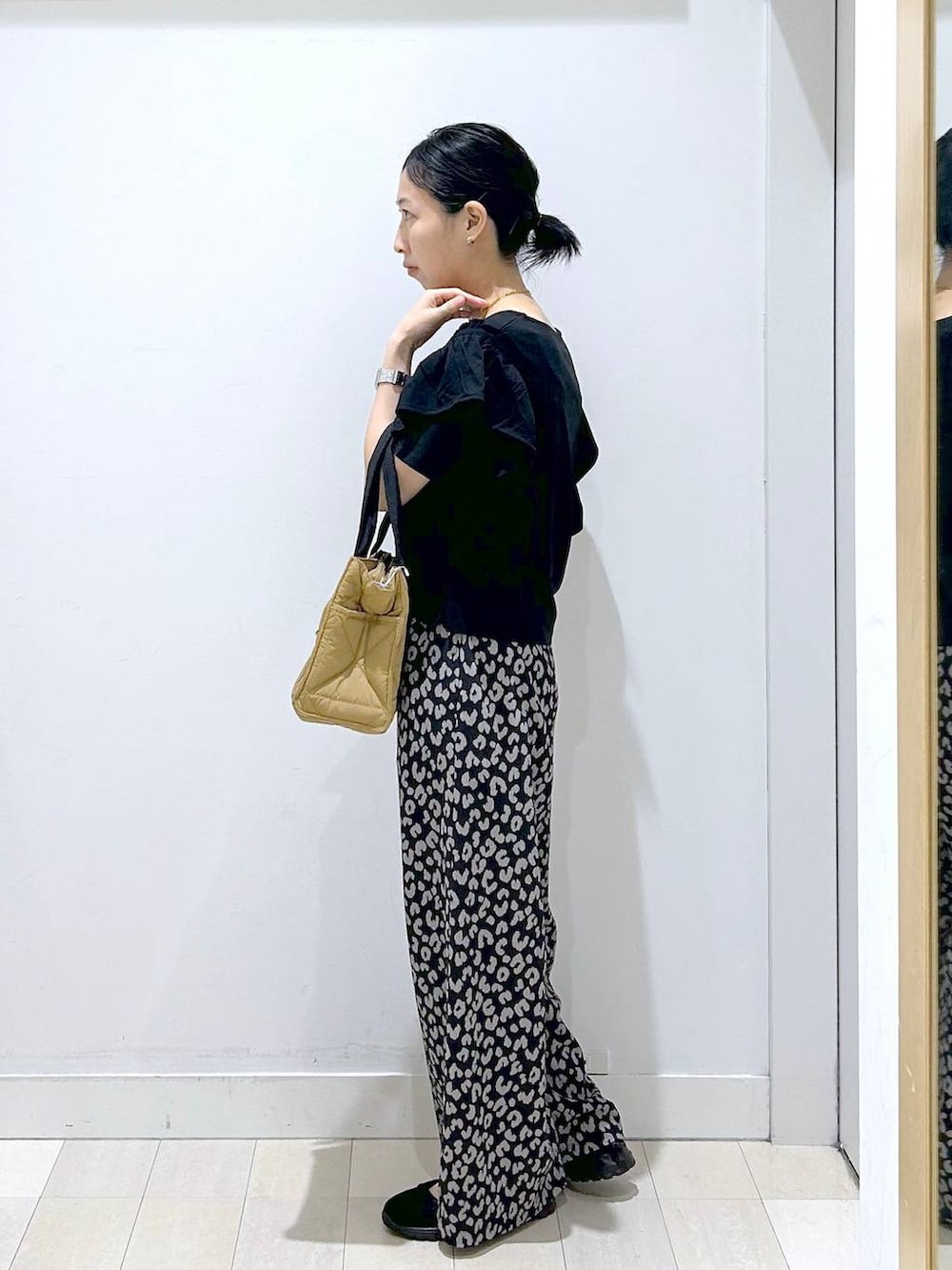 ブラウン系のトートバッグ、その他のその他パンツ、ブラック系のスニーカーを着用したレディースの春コーディネートの2枚目の写真