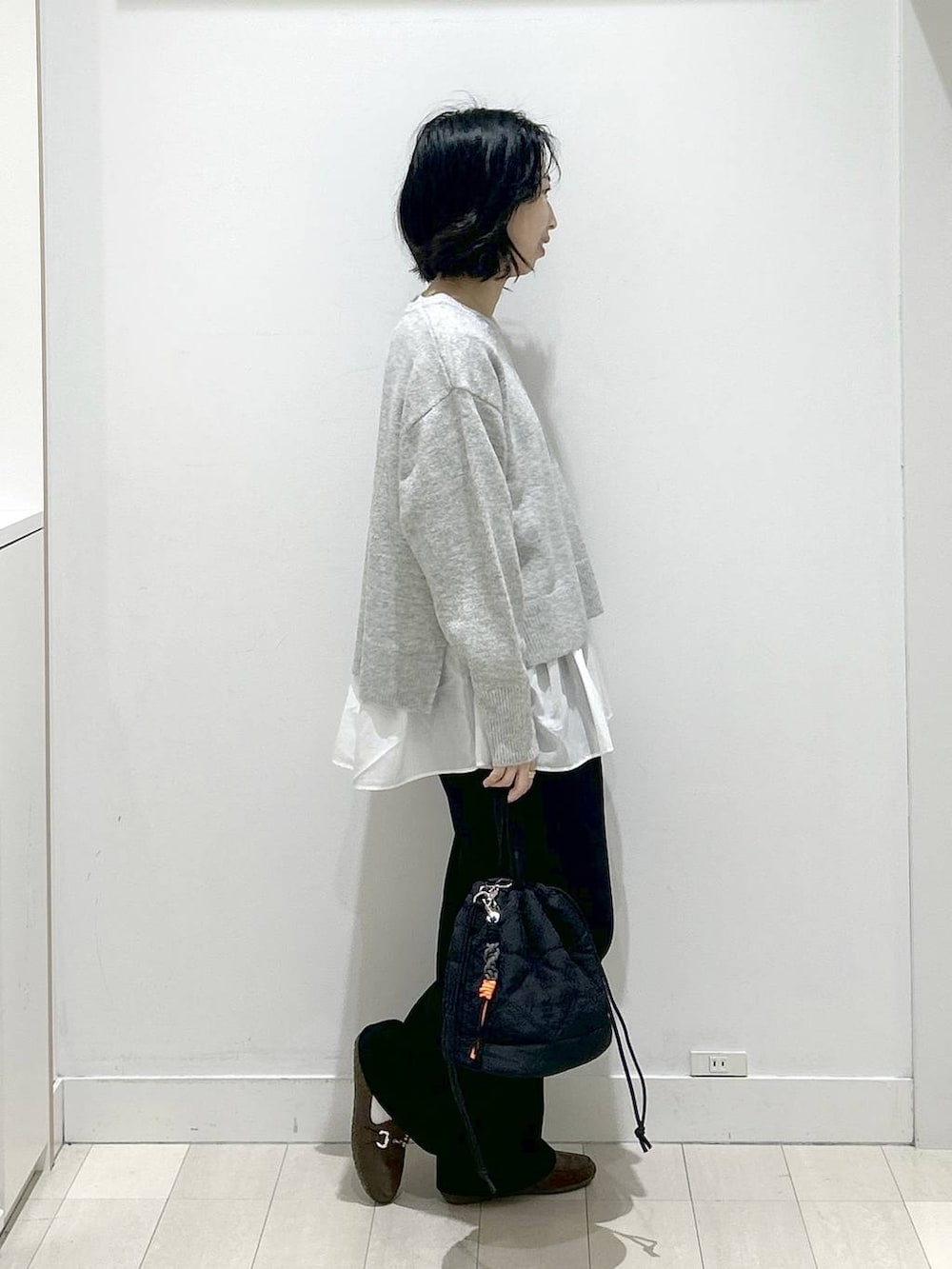 ブラック系のハンドバッグ、シルバー系のニット/セーター、ブラック系のその他パンツを着用したレディースの冬コーディネートの2枚目の写真