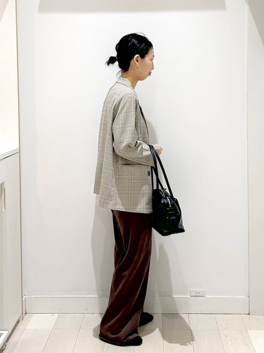 ブラック系のローファー、ブラック系のボストンバッグ、ブラウン系のスウェットパンツを着用したレディースの春コーディネートの4枚目の写真