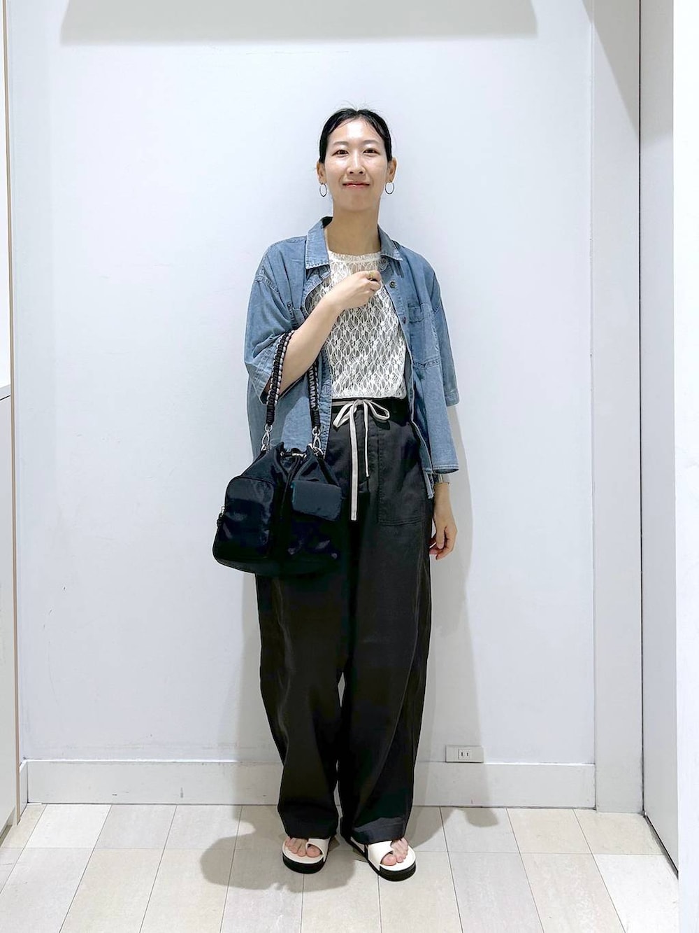 ブラック系のショルダーバッグ、ホワイト系のTシャツ/カットソー、ブルー系のシャツ/ブラウスを着用したレディースの夏コーディネートの5枚目の写真