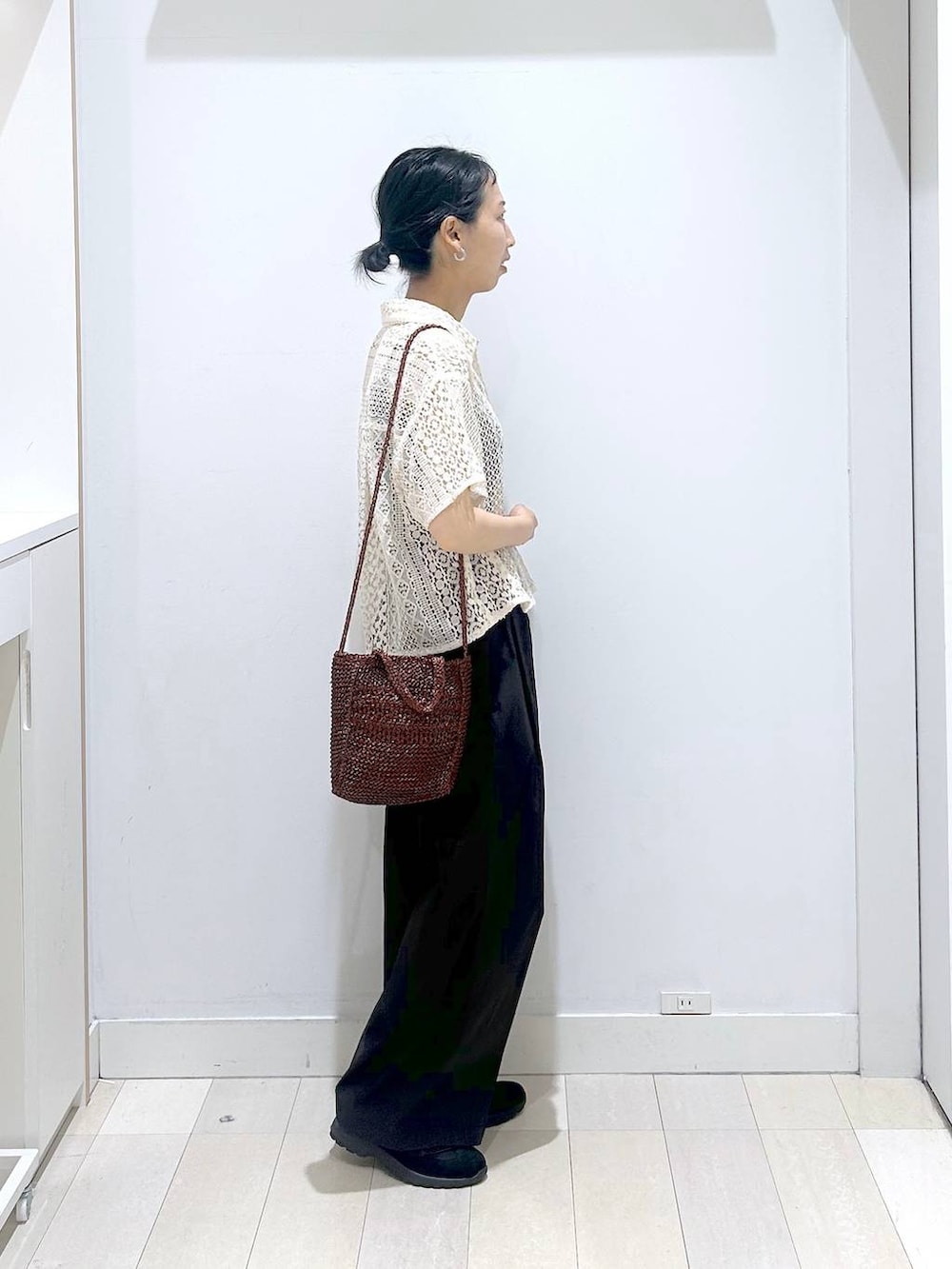 ブラック系のその他パンツ、ブラウン系のクラッチバッグ、ブラック系のスニーカーを着用したレディースの春コーディネートの4枚目の写真