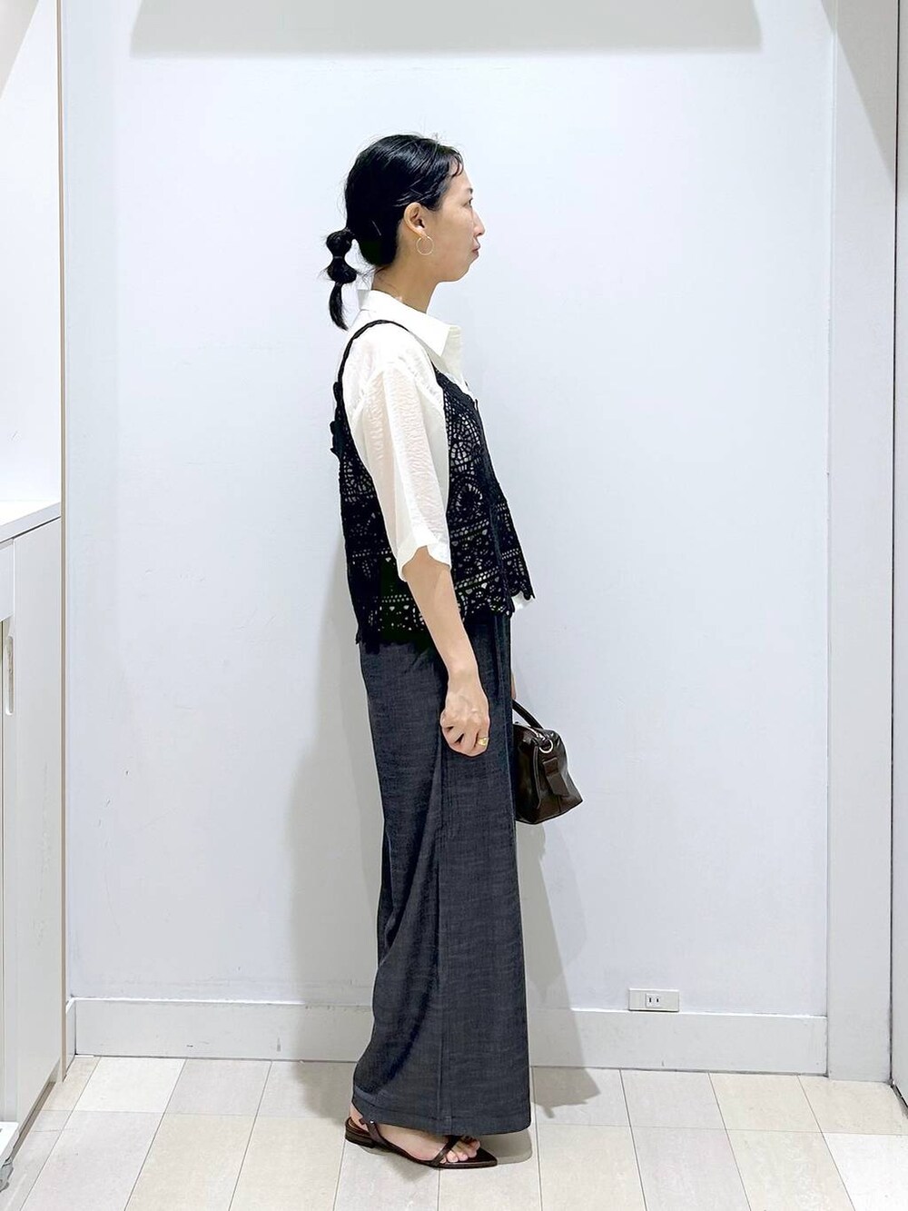 ブラック系のその他パンツ、ホワイト系のシャツ/ブラウス、ブラウン系のボストンバッグを着用したレディースの夏コーディネートの4枚目の写真