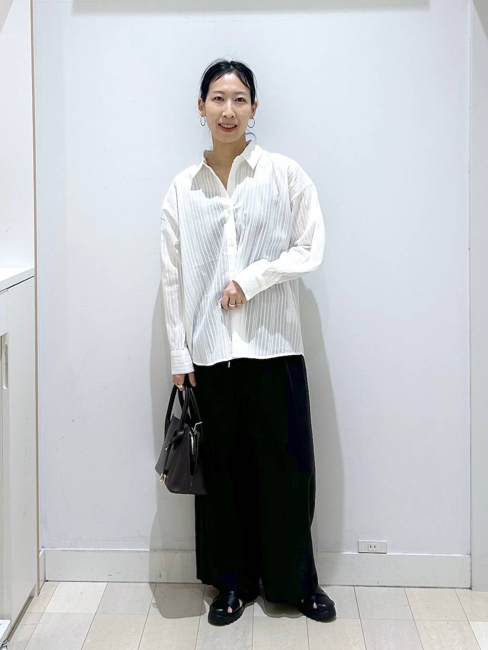 ブラック系のショルダーバッグ、ブラック系のその他パンツ、ブラック系のサンダルを着用したレディースの春コーディネートの5枚目の写真