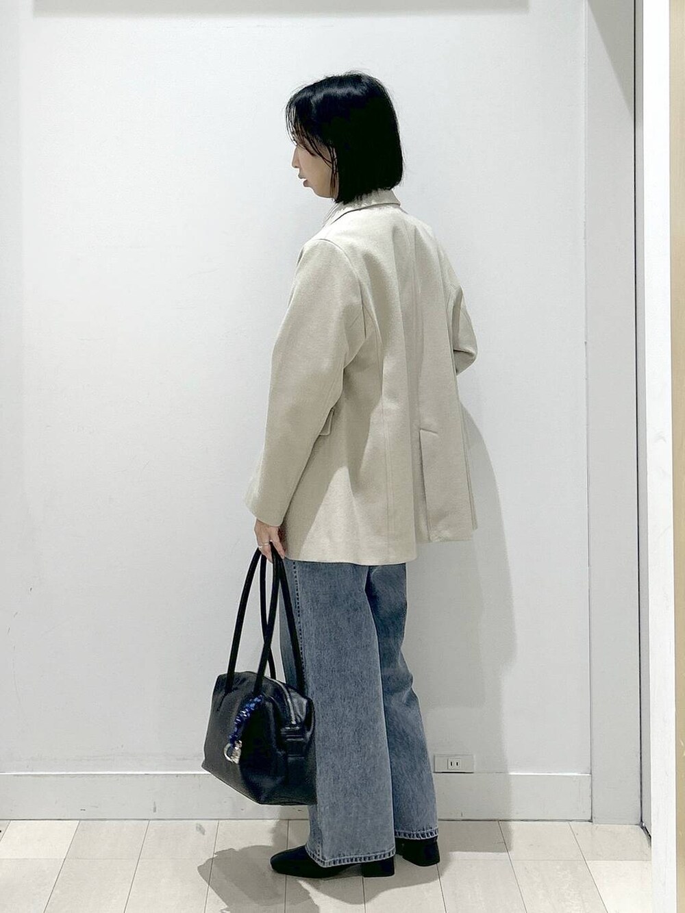 ブラック系のボストンバッグ、ブルー系のデニムパンツ、その他のシャツ/ブラウスを着用したレディースの冬コーディネートの4枚目の写真