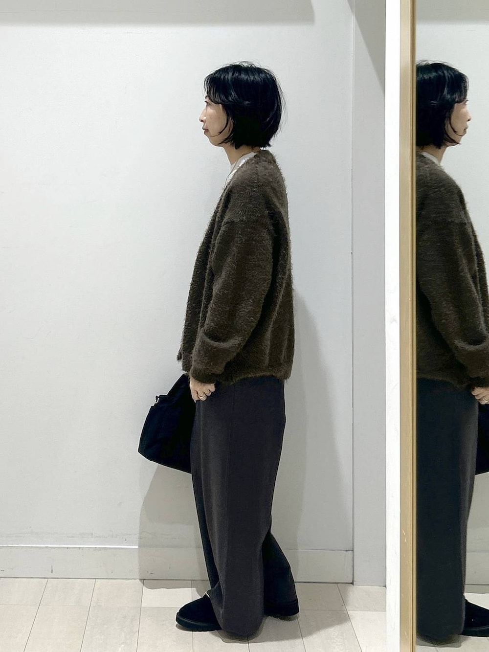 ブラック系のトートバッグ、グレー系のニット/セーター、ブラック系のローファーを着用したレディースの秋コーディネートの4枚目の写真