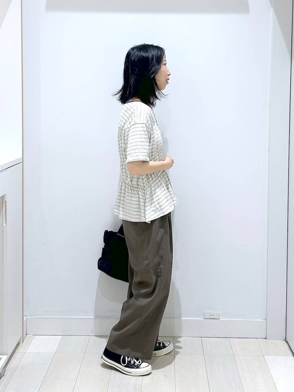 ブラック系のトートバッグ、ブラウン系のその他パンツ、ホワイト系のTシャツ/カットソーを着用したレディースの夏コーディネートの4枚目の写真