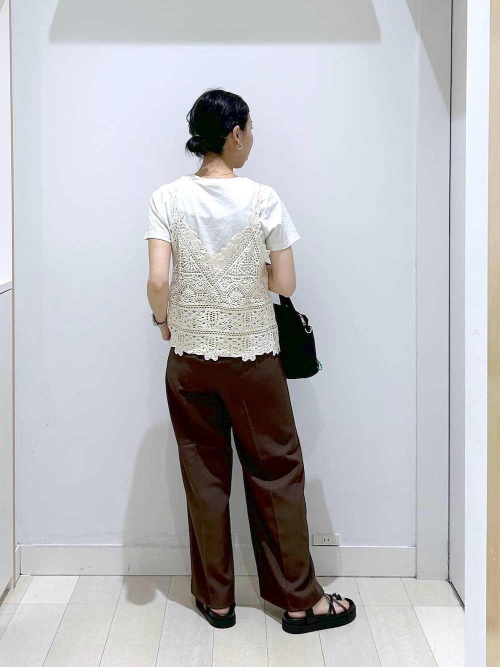 ブラック系のトートバッグ、ブラウン系のその他パンツ、ホワイト系のTシャツ/カットソーを着用したレディースの夏コーディネートの3枚目の写真