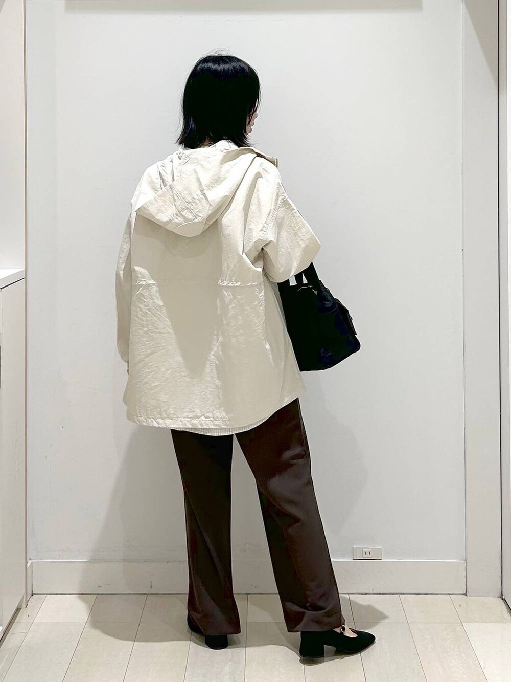 ブラック系のトートバッグ、ベージュ系のパーカー、ブラウン系のその他パンツを着用したレディースの春コーディネートの4枚目の写真