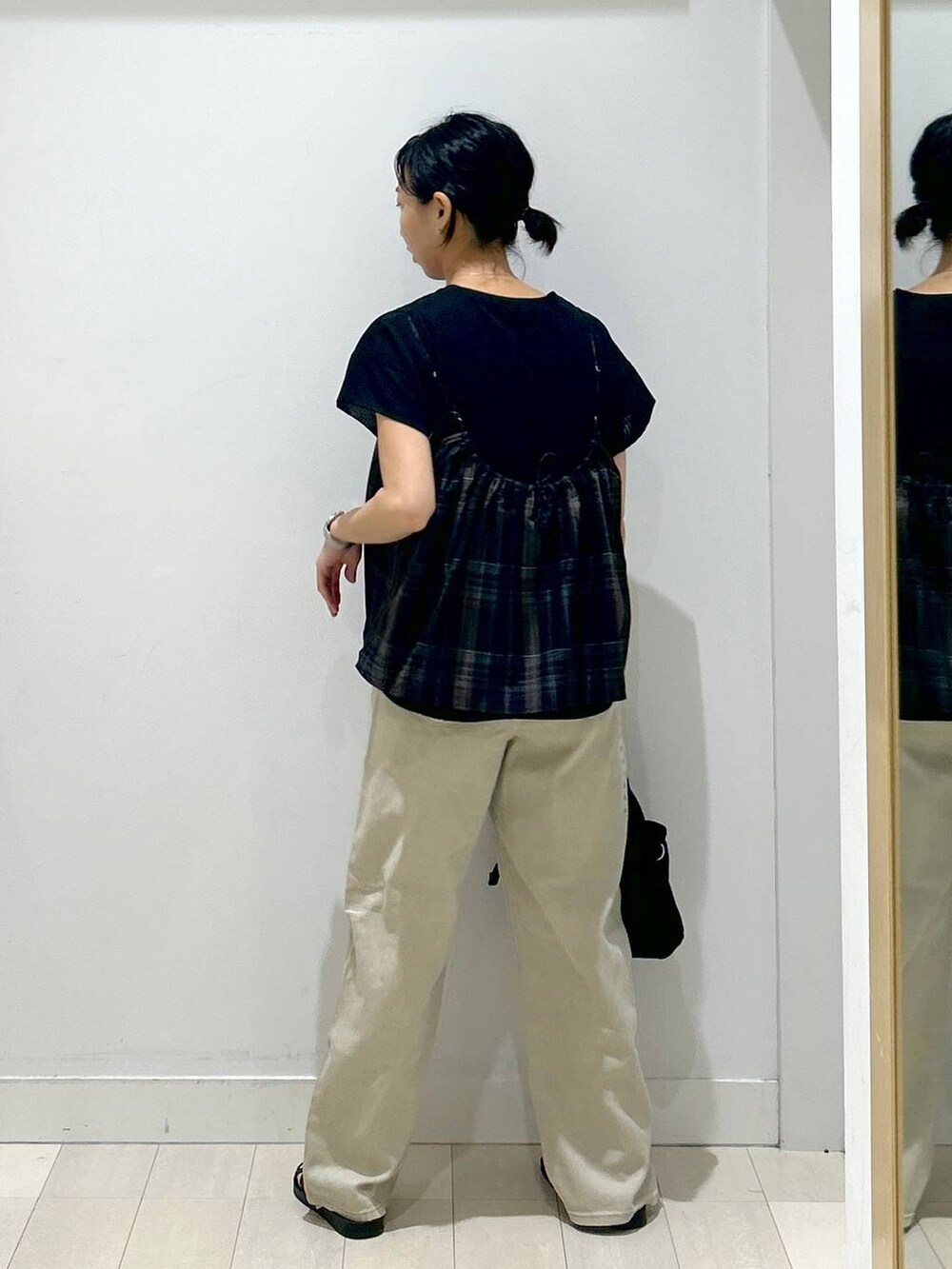 ブラック系のトートバッグ、ブラック系のサンダル、ブラック系のTシャツ/カットソーを着用したレディースの夏コーディネートの3枚目の写真