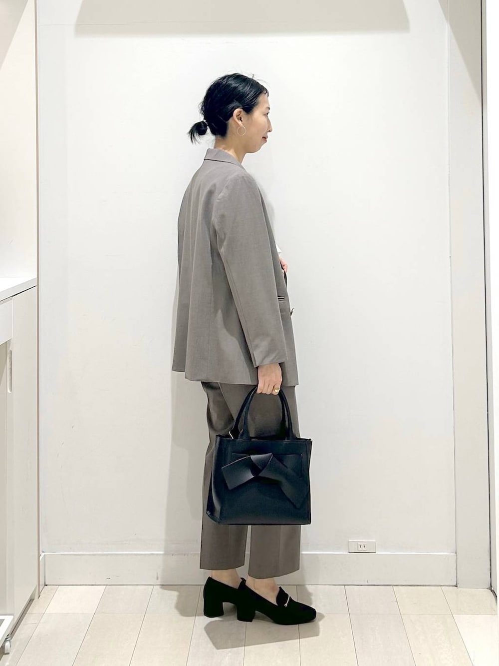 ブラック系のローファー、ブラウン系のスラックス、ホワイト系のシャツ/ブラウスを着用したレディースの春コーディネートの2枚目の写真